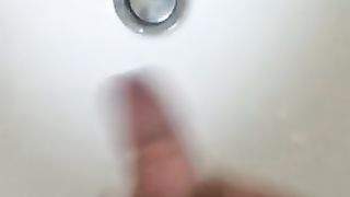 Обнаженный гей с айфоном в руке дрочит член в ванне до эякуляции