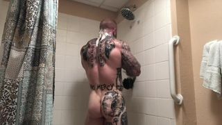 Накачанный мужик с татуировками на теле мастурбирует хуй