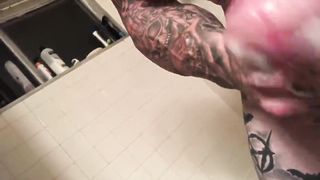 Накачанный мужик с татуировками на теле мастурбирует хуй