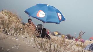 Парень на пляже подсматривает за обнаженными нудистами