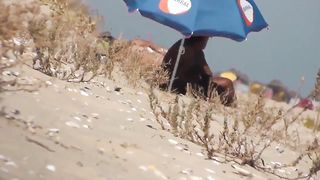 Парень на пляже подсматривает за обнаженными нудистами