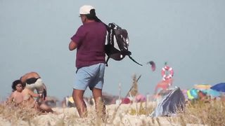 Парень на пляже подсматривает за обнаженными нудистами