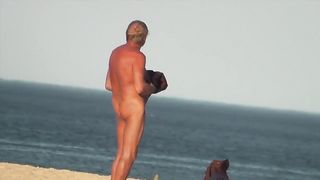 Парень на пляже подсматривает за обнаженными нудистами