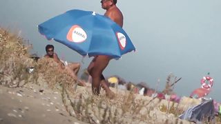 Парень на пляже подсматривает за обнаженными нудистами