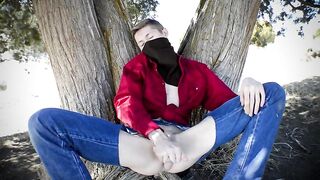 Парень в рваных джинсах дрочит под деревом